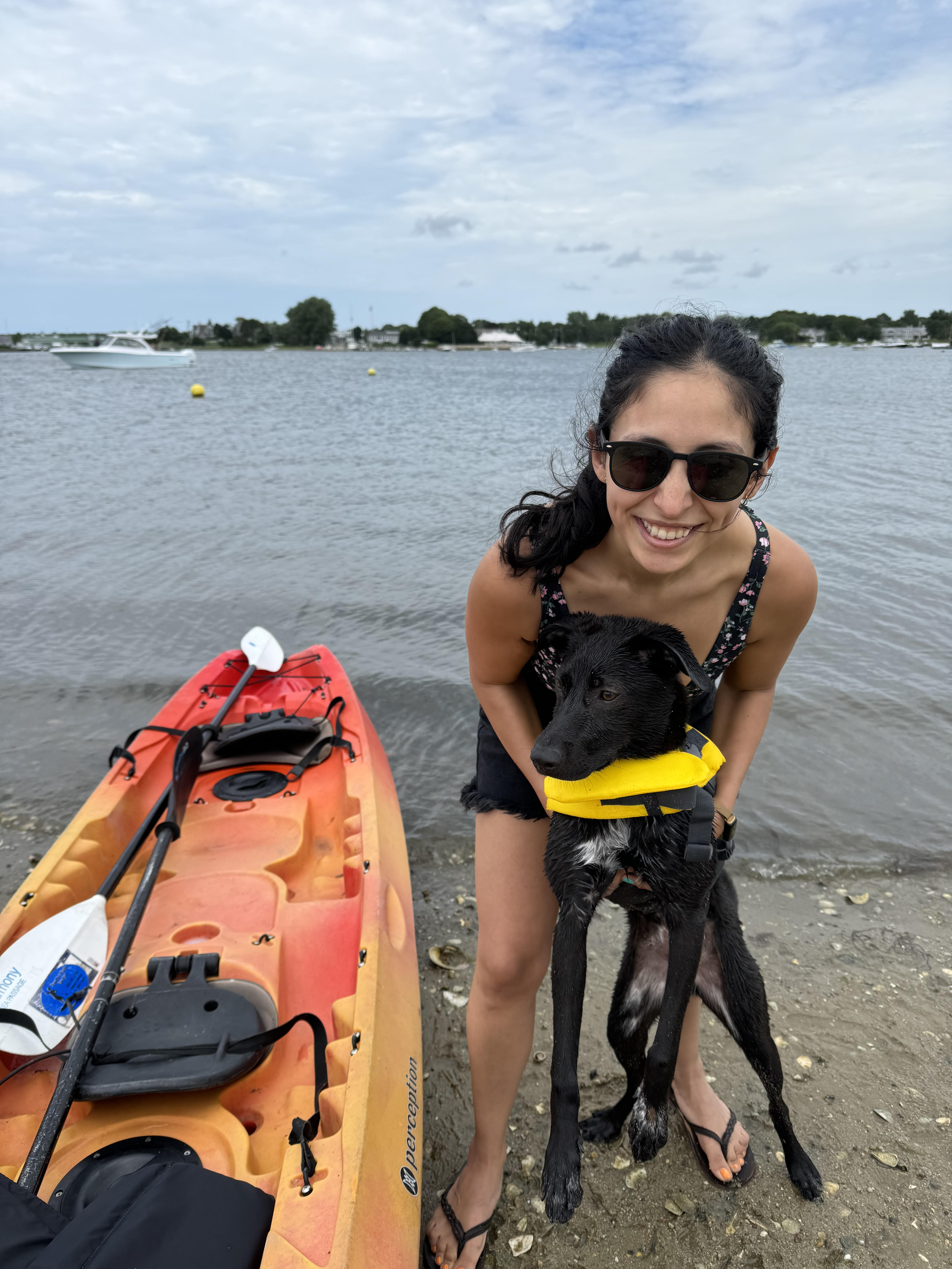 Jenni Gargano at the beach with a dog and a kayak. 