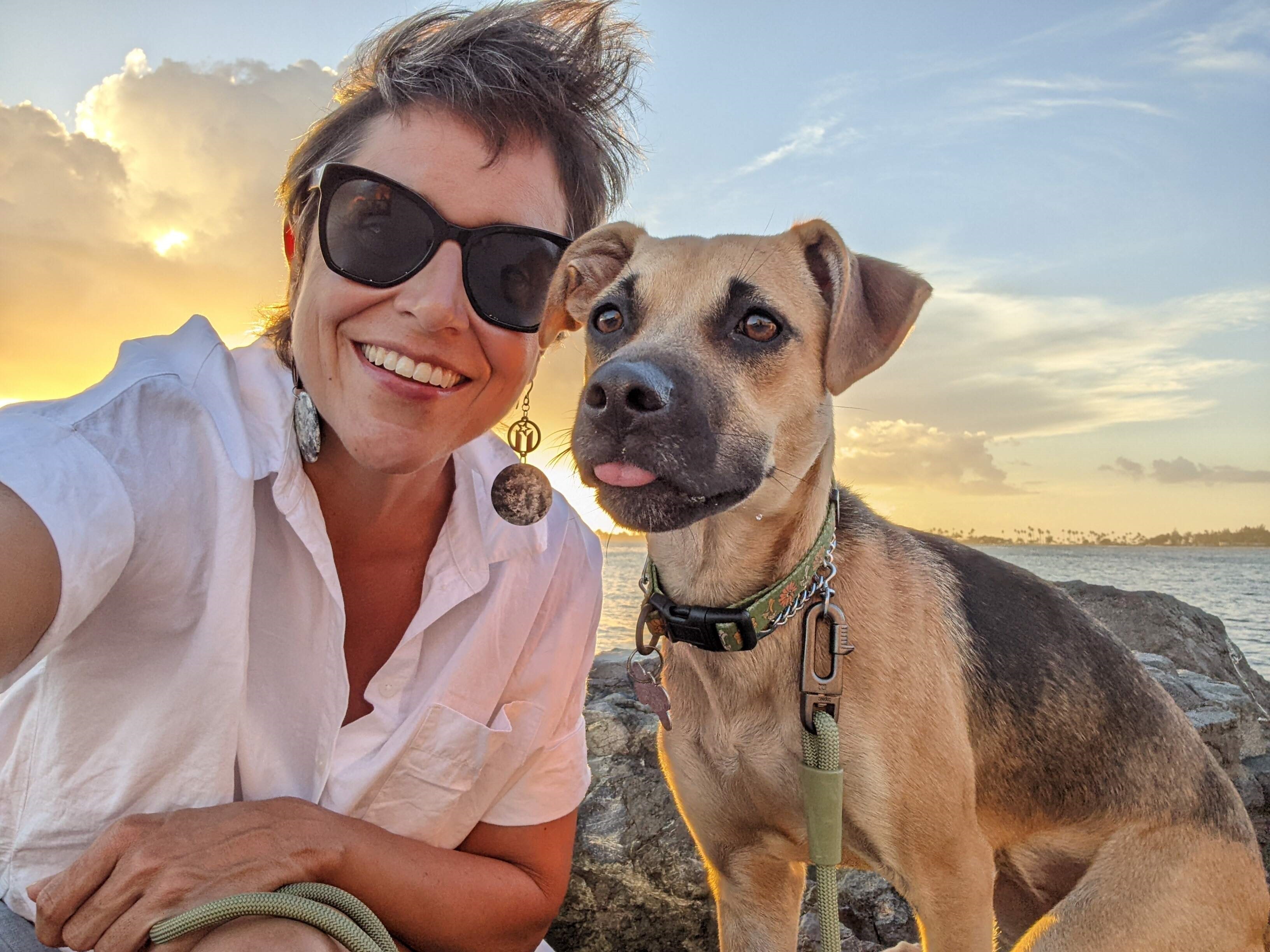 DJ Meehan and dog posing in front of sunset